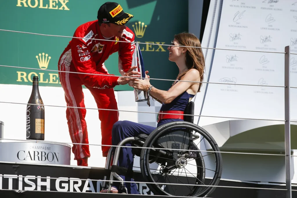 The F1 Podium Nathalie McGloin handing Kimi Raikkonen the trophy on the F1 podium at Silverstone